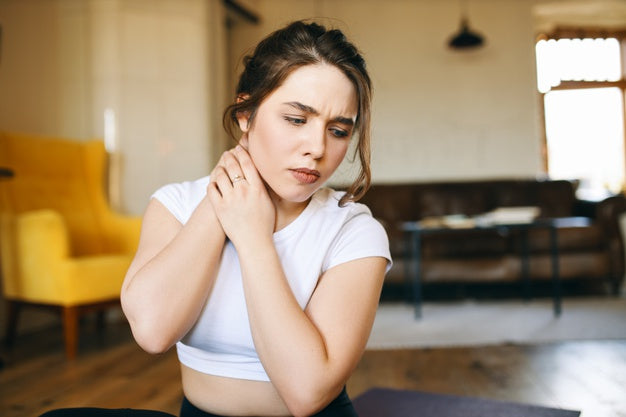 A woman holding her neck in pain