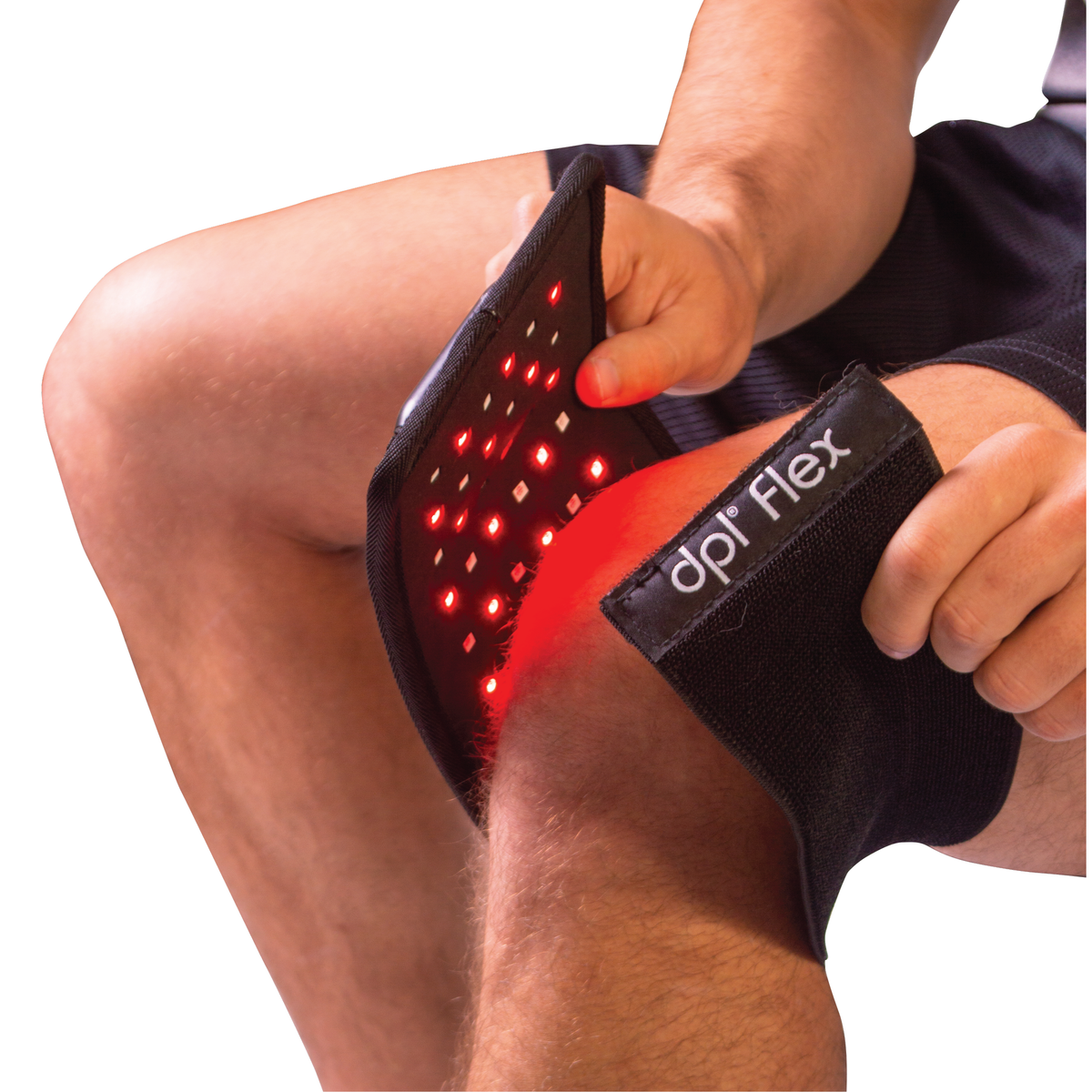 A man placing a red light therapy wrap over his knee