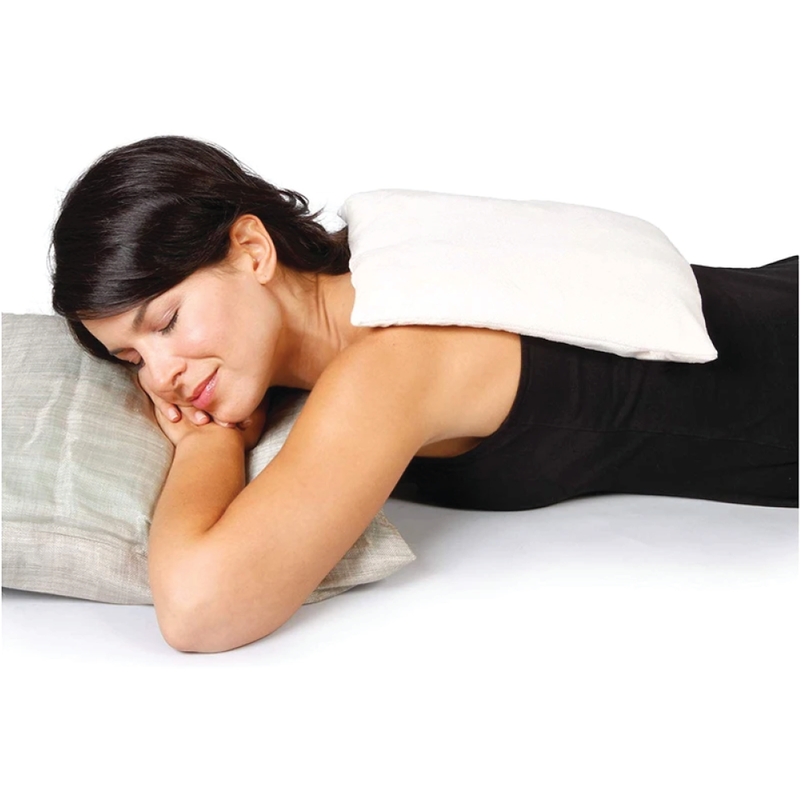 A woman laying down with a comfort pack on her back