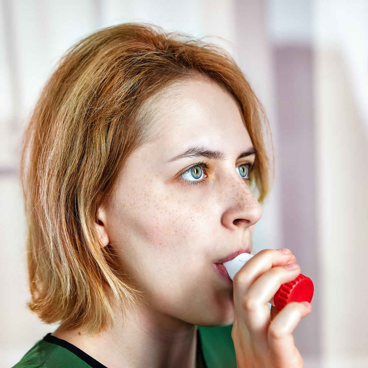 A woman using an inhaler