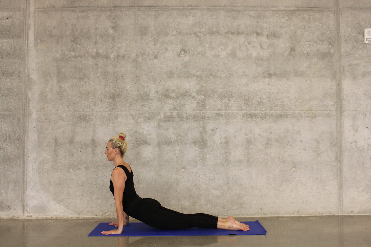 A woman doing a hip stretch on a yoga mat