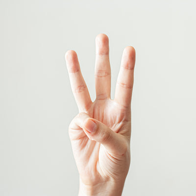 A person holding three of their fingers up