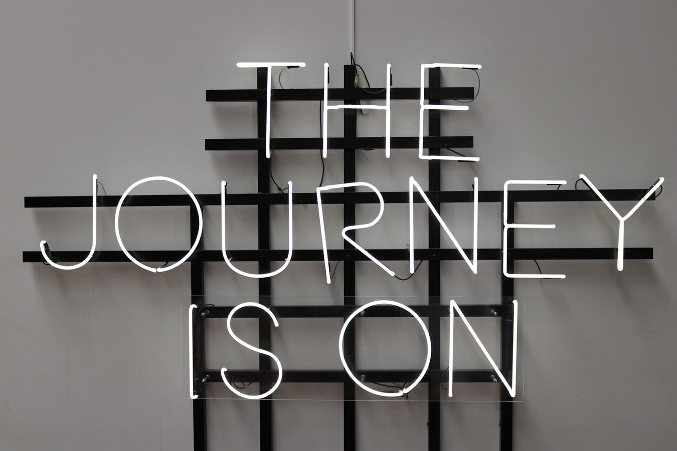 A neon sign that reads “the journey is on”