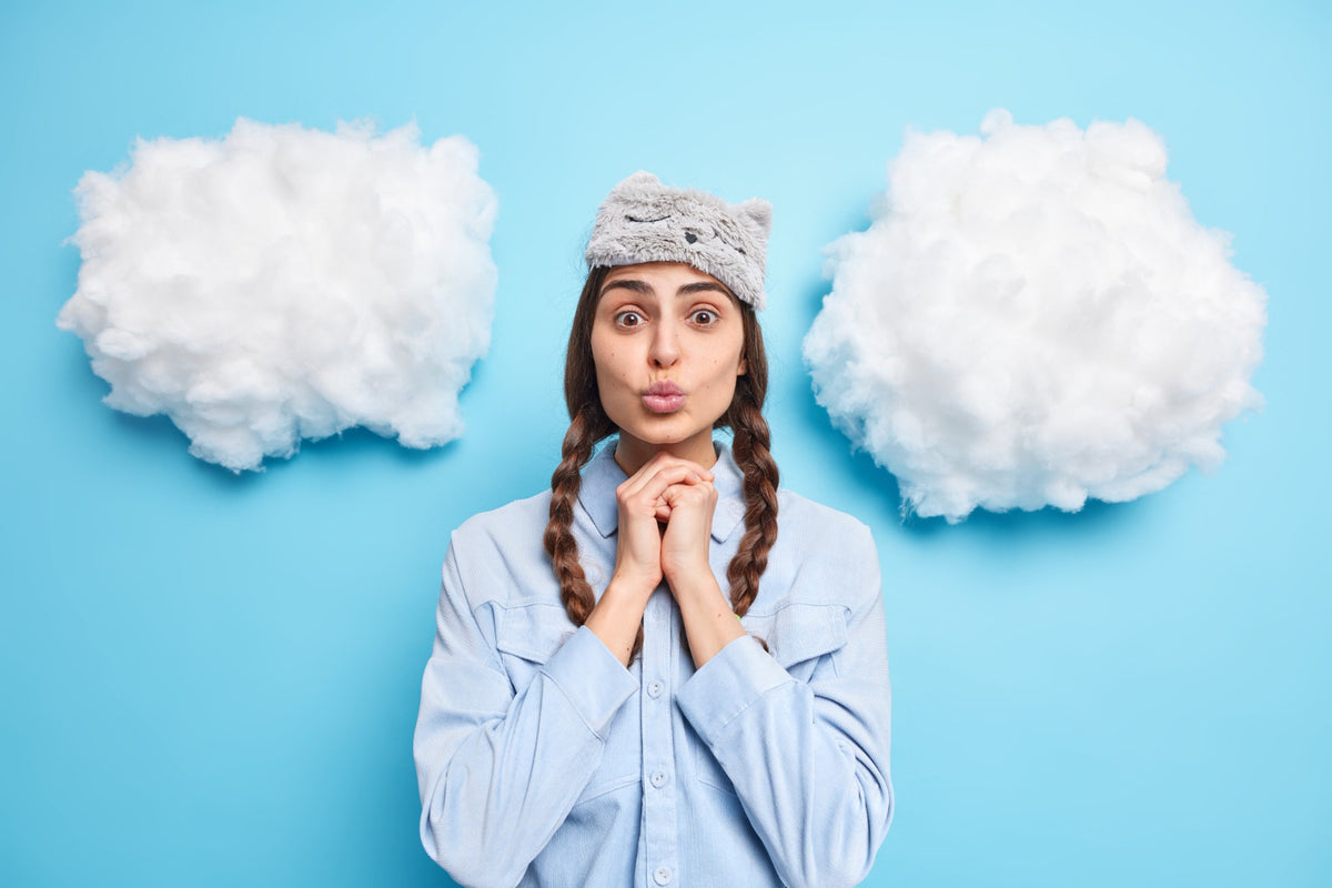 A woman in PJs next to clouds on a blue background