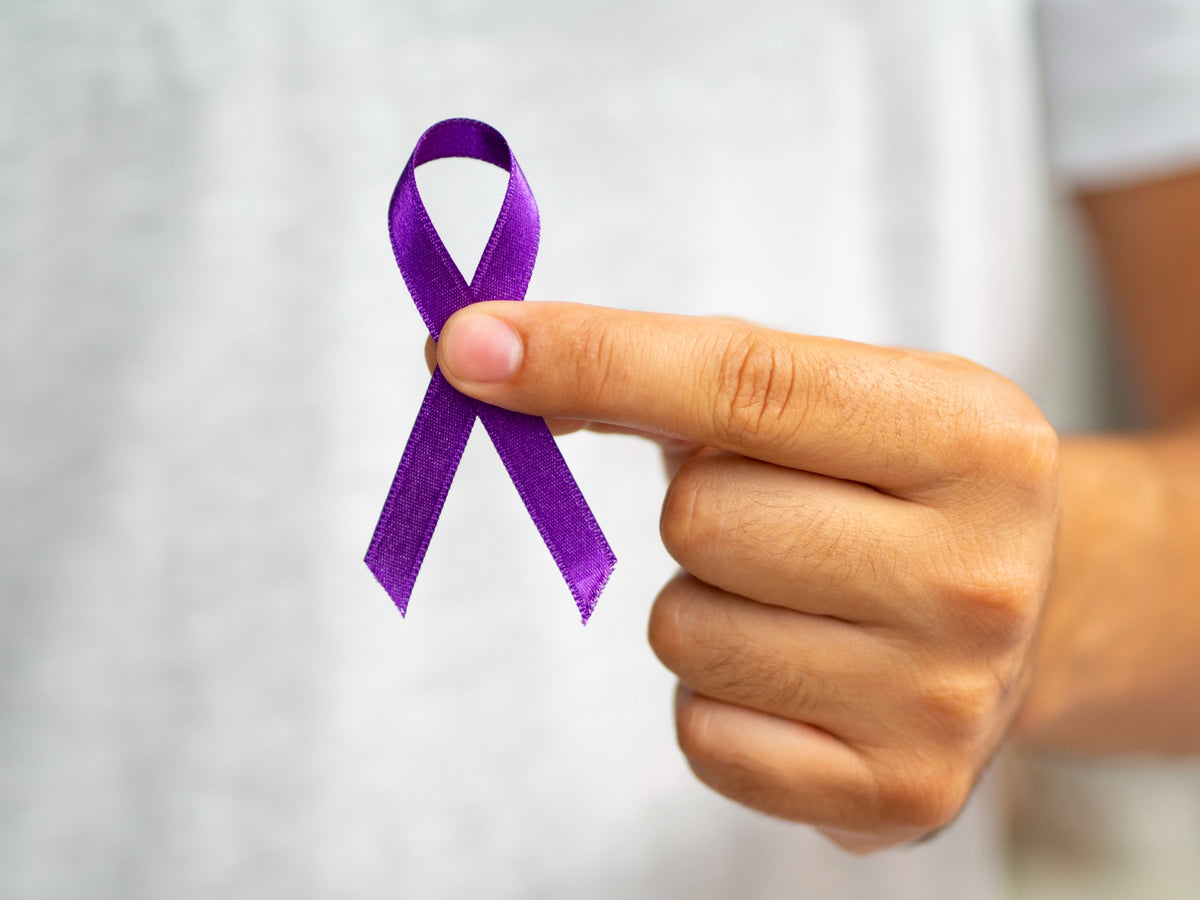 A man holding a purple ribbon