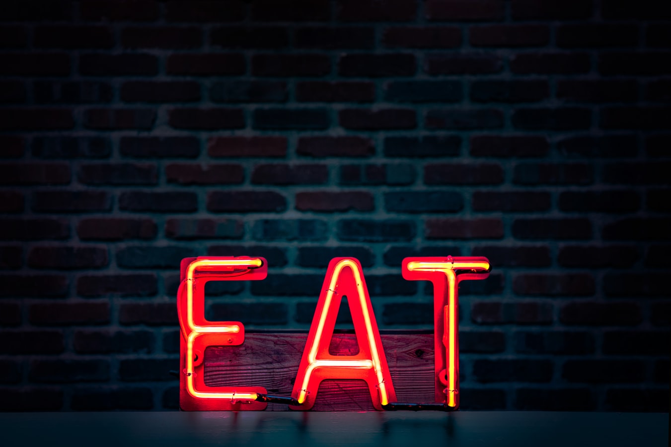 A neon sign that reads “EAT”