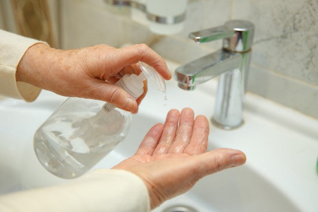 A pair of hands squirting soap on their hands