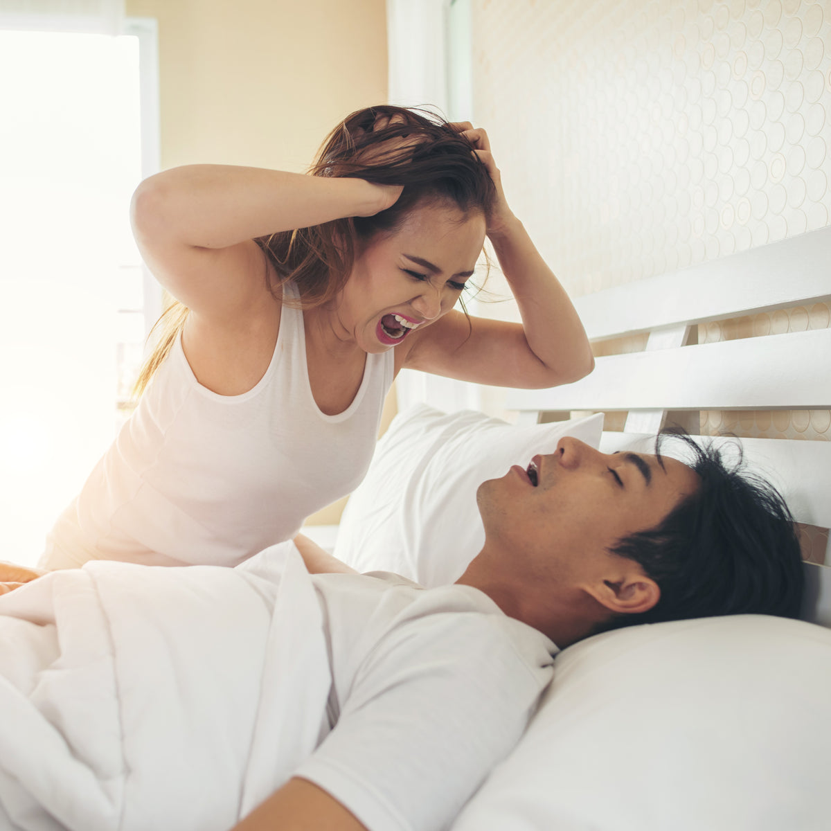A woman screaming at a sleeping man who’s snoring