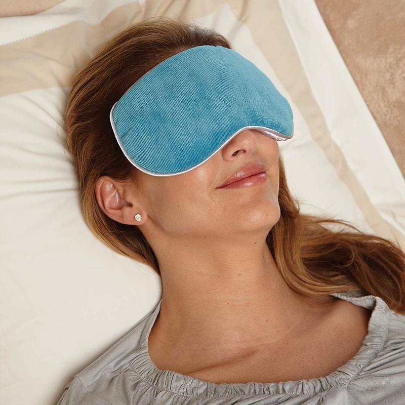 A woman lying down with the Bed Buddy Relaxation Mask over her eyes 