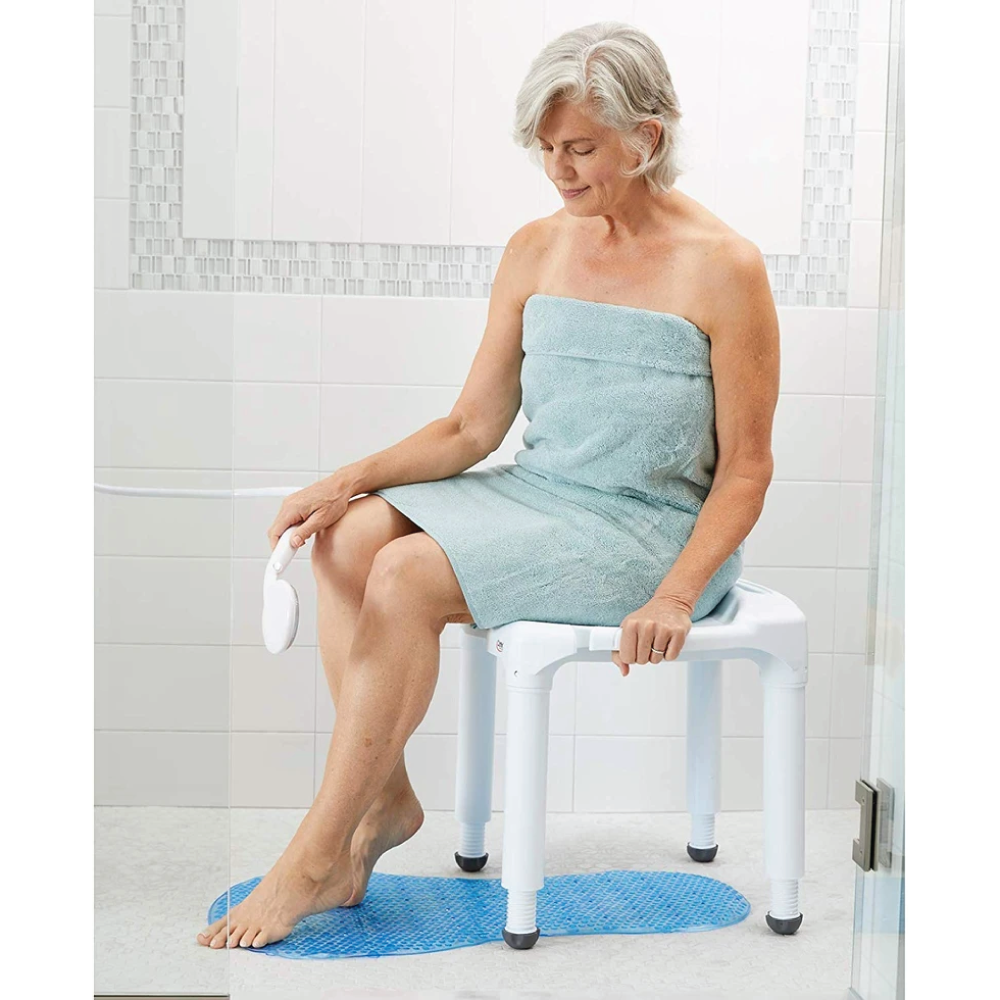 An elderly woman sitting on a shower seat in a shower