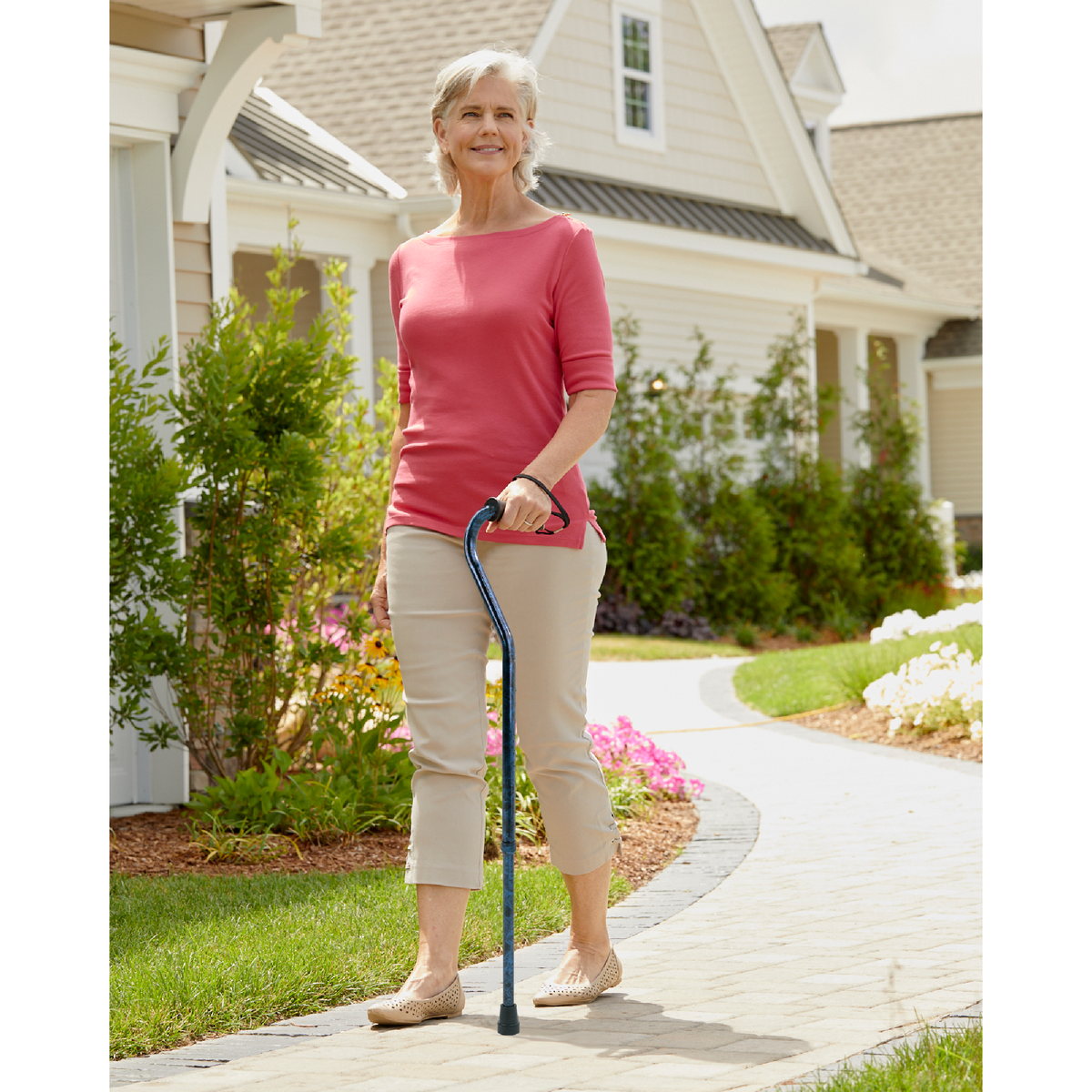 A women walking outside while holding walking cane tips