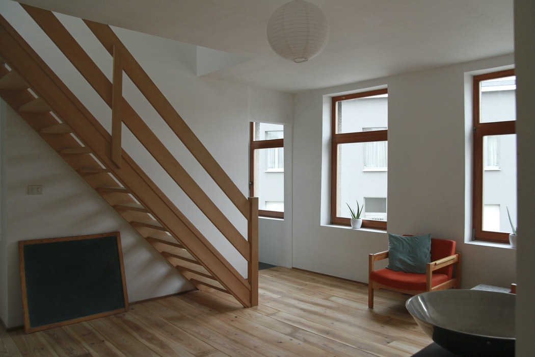 A living room with a wooden floor and stairs