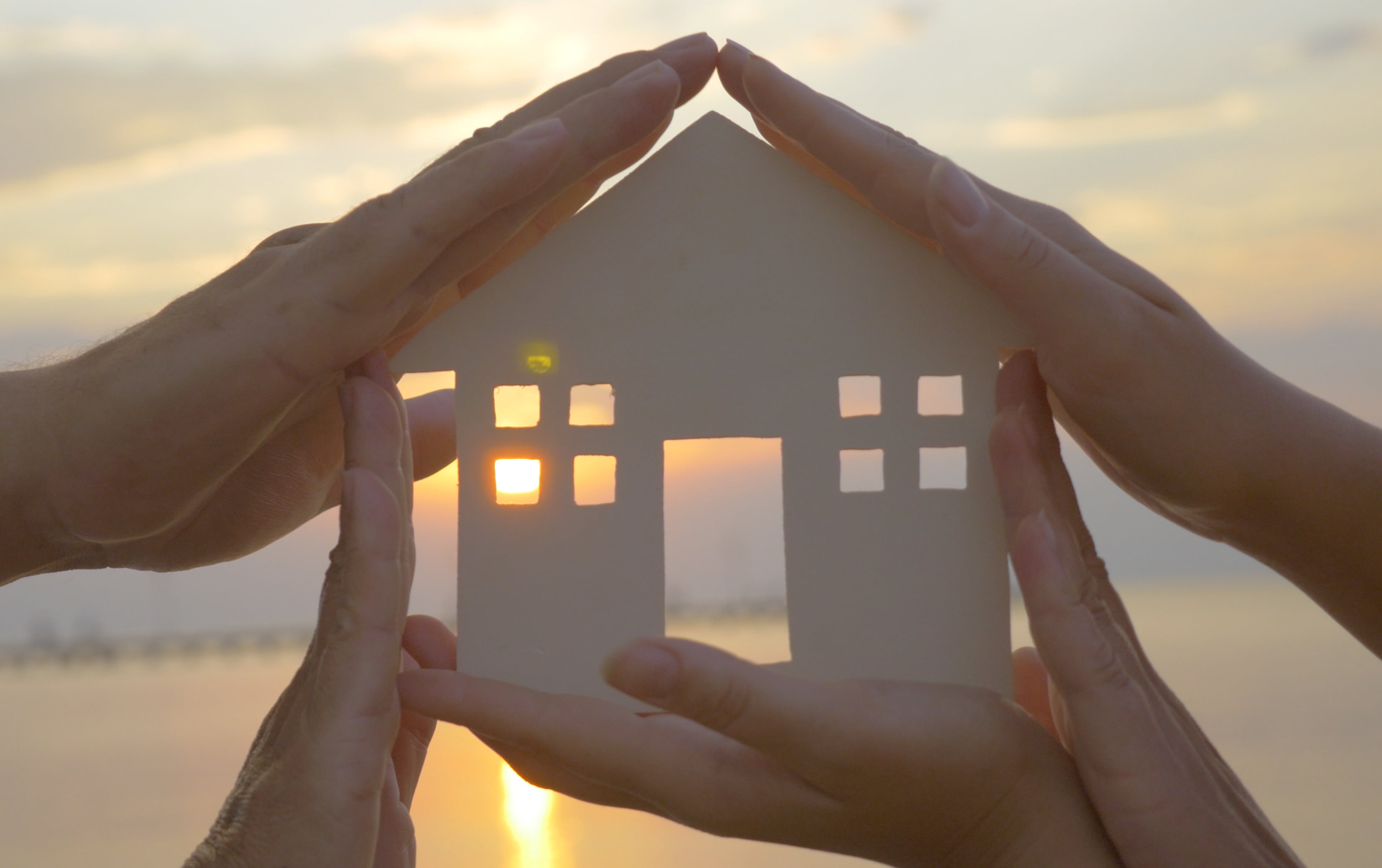 A group of hands holding a cutout home