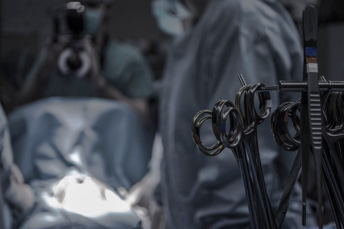 Various surgery instruments with a doctor doing surgery in the background