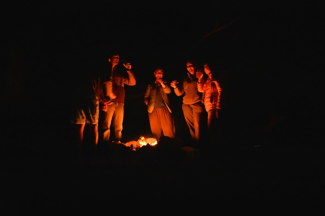 Five people standing in front of a fire