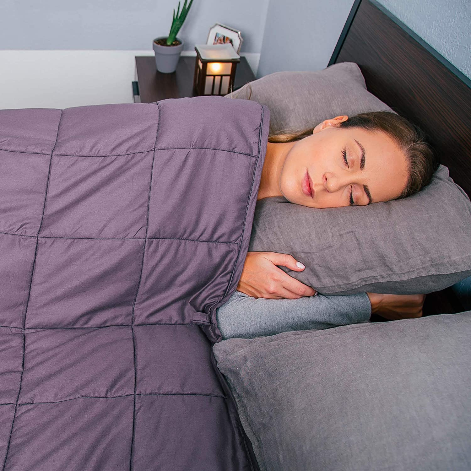 A woman sleeping with a weighted blanket over her