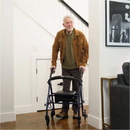 An elderly man turning a corner with a rollator in a home