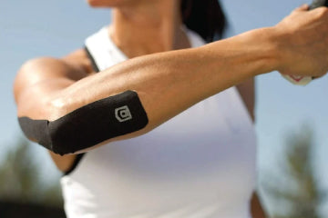 A woman with kinesiology tap on her elbow
