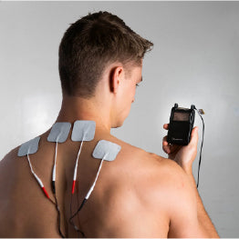 A shirtless man with electrodes on his neck holding the Twin Stim TENS Unit
