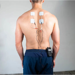 A shirtless man with electrodes on his upper back and the Twin Stim TENS Unit clipped to his waist