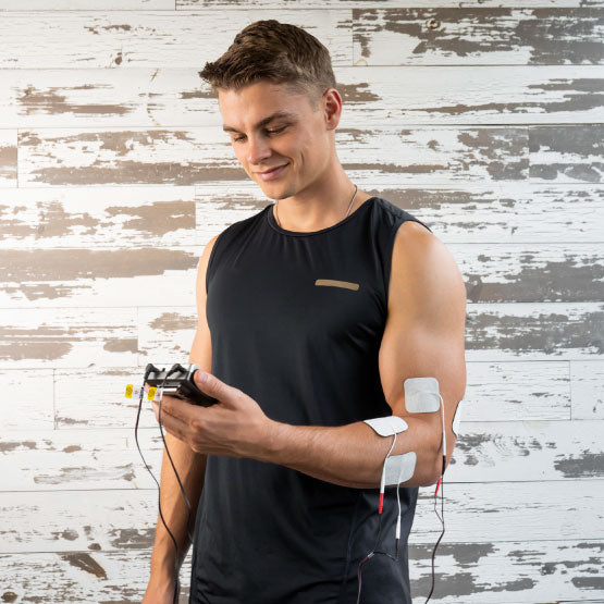 A man holding a TENS unit