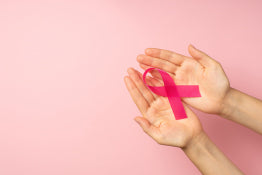 Hands holding a pink cancer ribbon