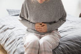 A woman holding her stomach in pain