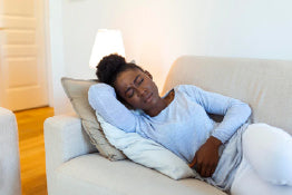 A woman on a couch with menstrual pain