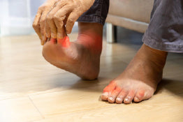 A man holding his toe experiencing pain from plantar fasciitis