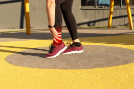 A woman holding her ankle in pain from tendonitis