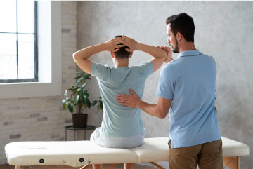 A physical therapist aligning a patient’s back