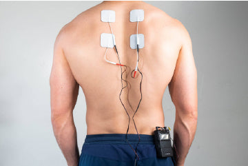 A man’s back with electrodes attached to his upper back and a TENS unit on his hip