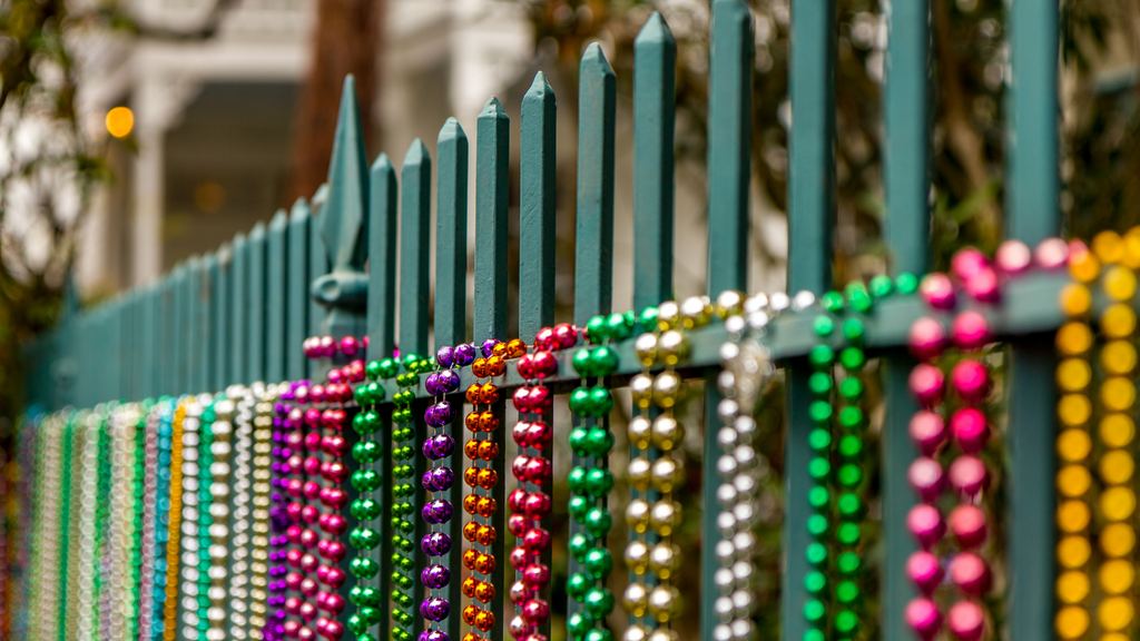 Colorful Mardi Gras beads hang from a New Orleans fence