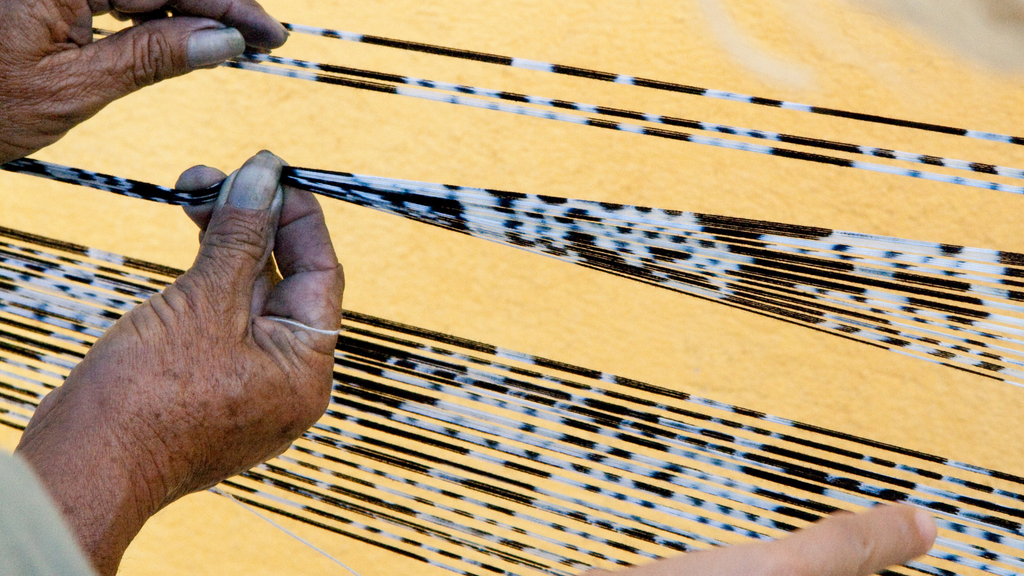 A person binds yarn to make ikat print fabric