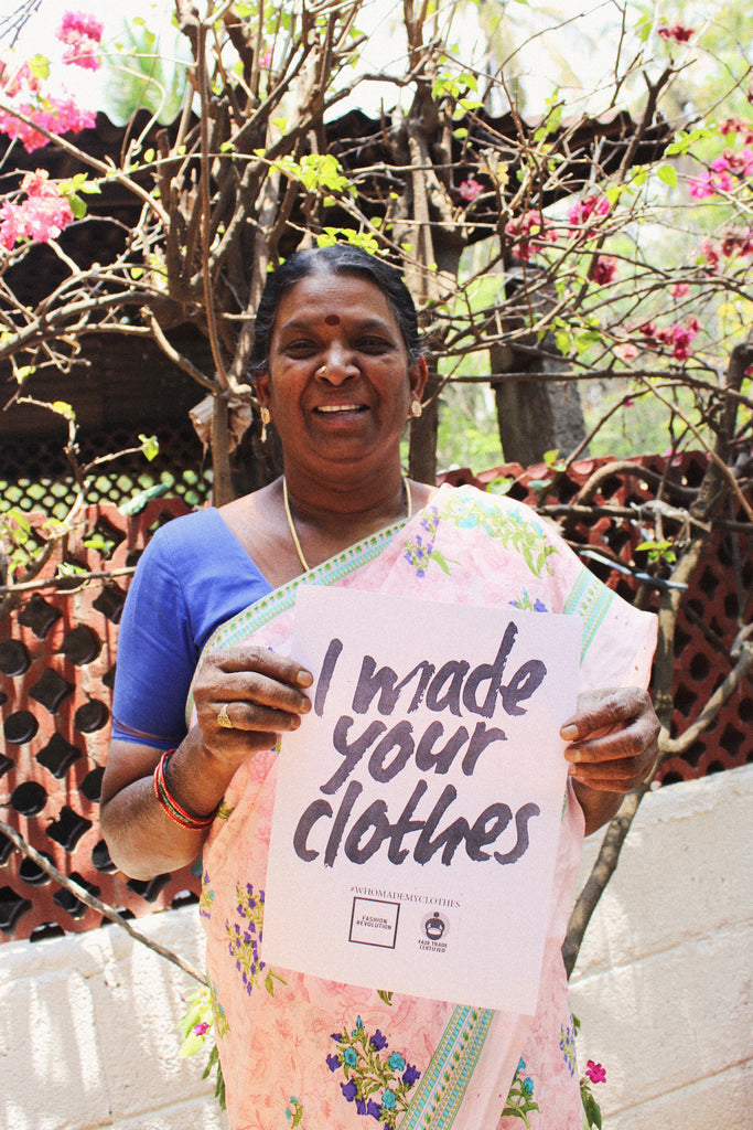 Female artisan holds up "I made your clothes" sign