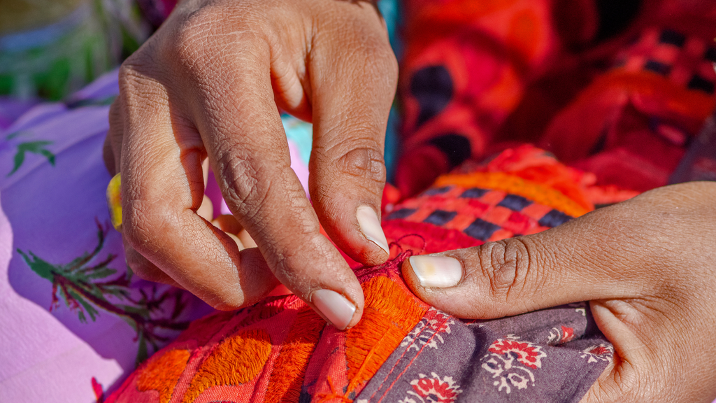 Indian woman embroiders fabric