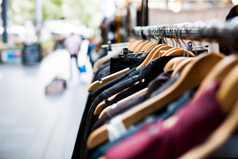 Shirts, pants, and jackets on a clothes rack, any of which could feature political fashion trends.