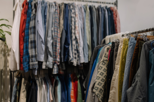 Used clothing hangs on thrift store racks