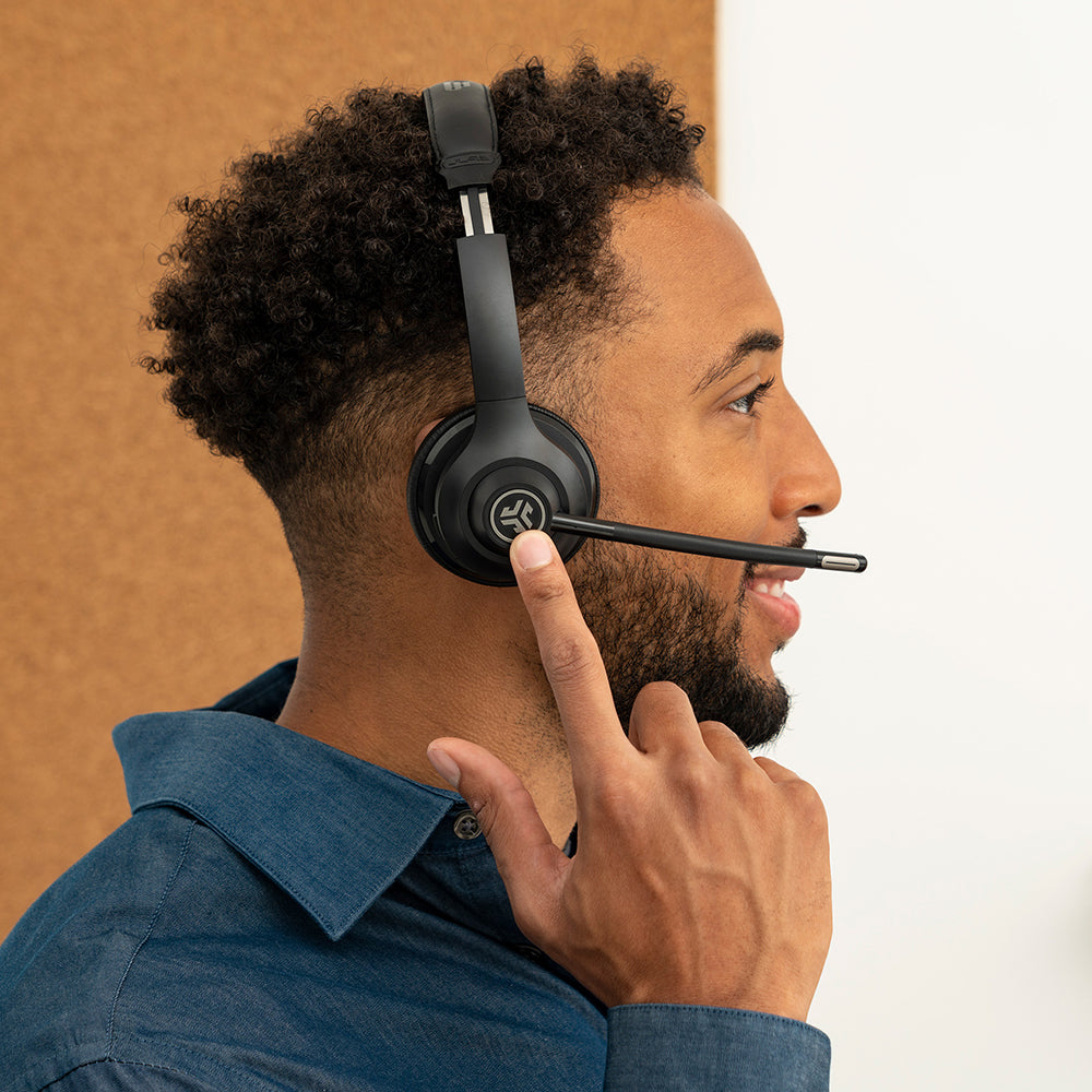 Man wearing GO Work Wireless On-Ear Headset and reaching for controls on earcup