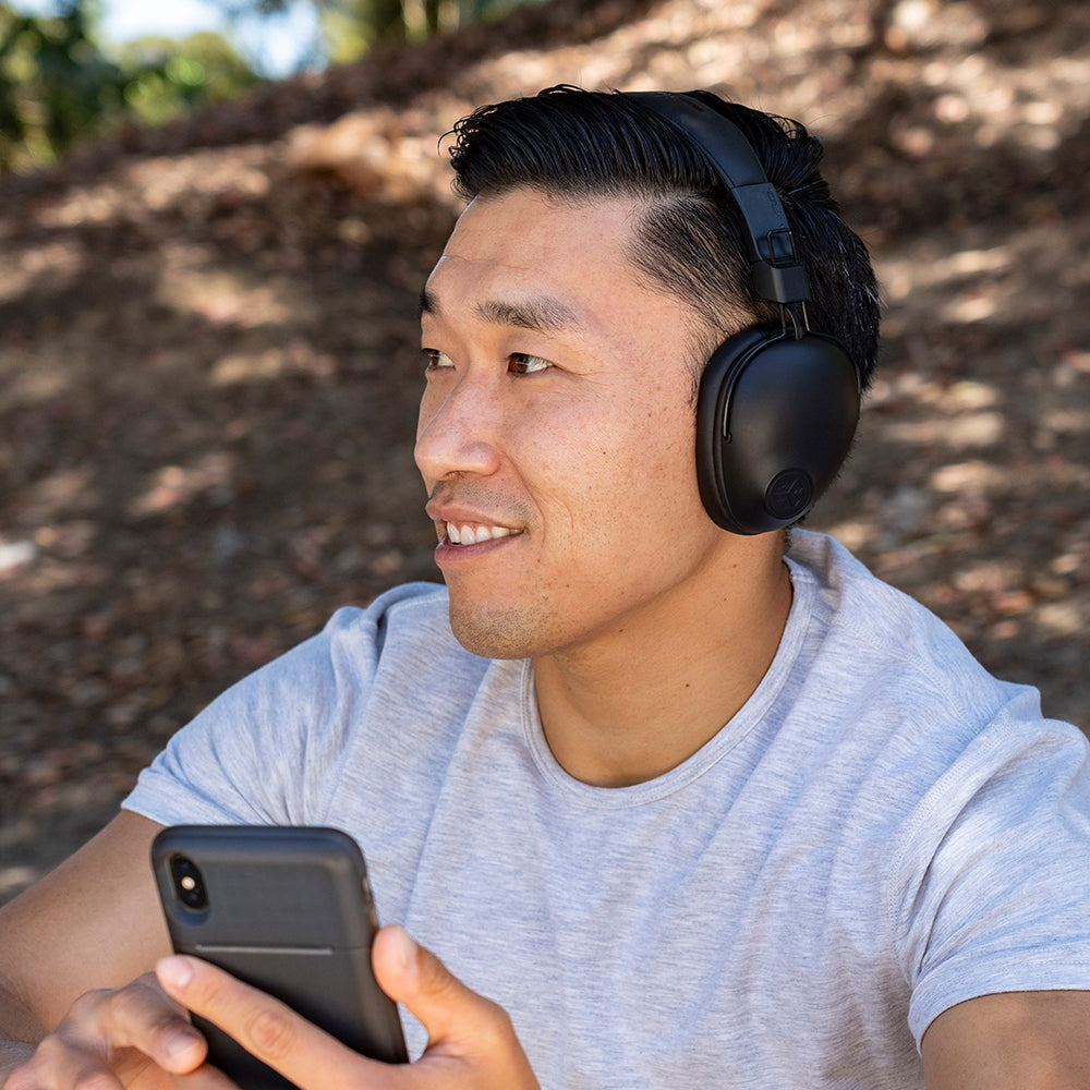 Man wearing black Studio Pro Wireless Over-Ear Headphones and holding cell phone