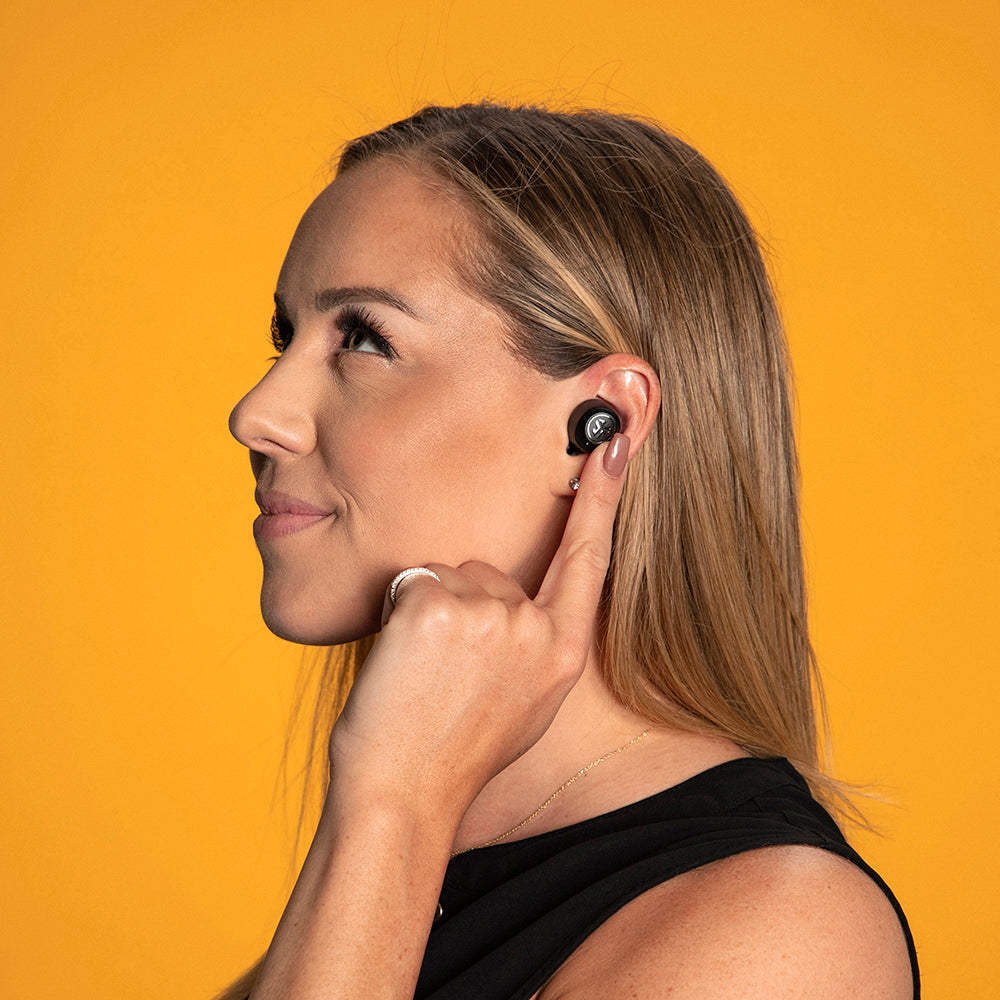 Woman wearing JBuds Air ANC True Wireless Earbuds and using touch sensors