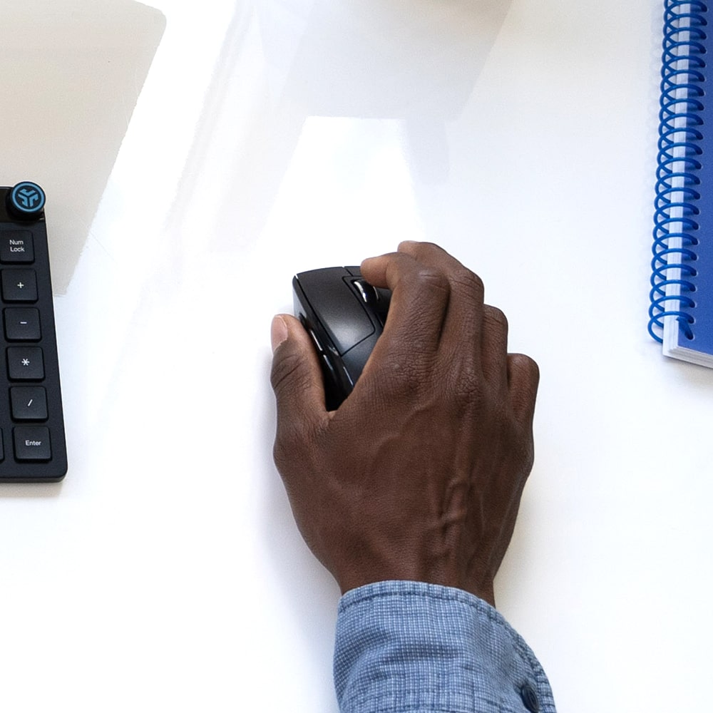 Hand on the desk holding JBuds Mouse