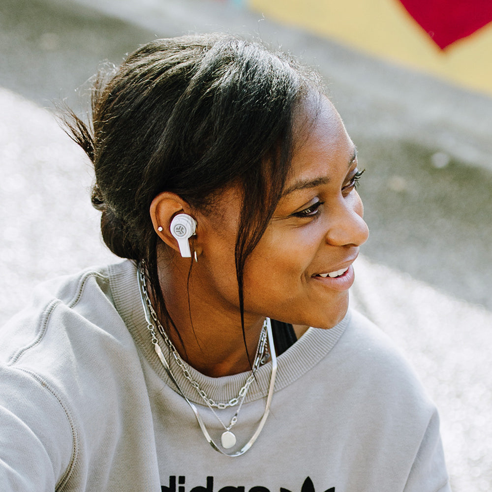 Side profile of woman wearing white JBuds Air Executive True Wireless Earbuds