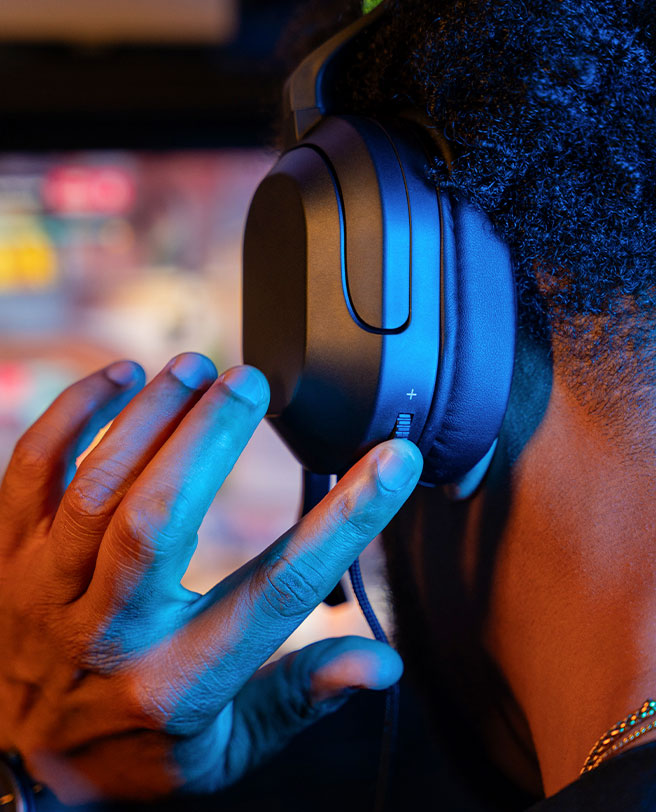 Man changing the volume on the JLab Nightfall Gaming headset