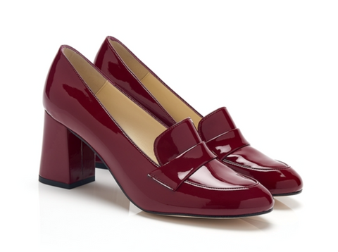 A pair of red loafer-like shoes with a tan lining, rounded toes, and a tall, wide, rectangular heel.