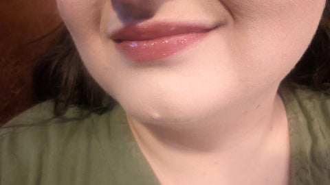 A close-up of Cat's mouth. She is a white woman wearing a shiny pink lipstick.