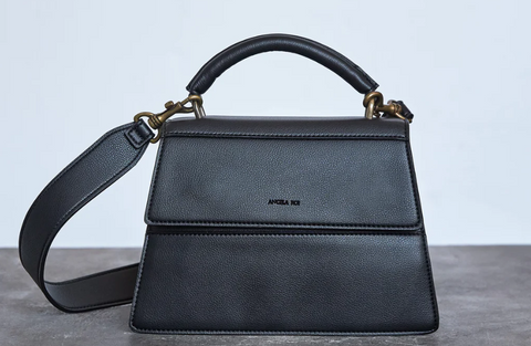 A black satchel with a top handle and shoulder strap.