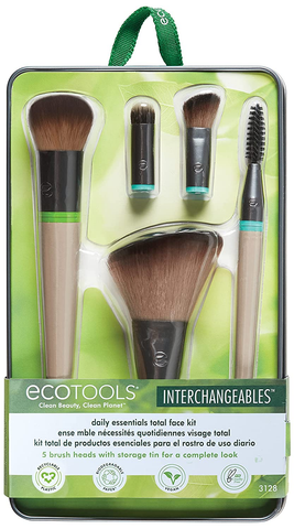 A set of interchangeable makeup tools. They are held in a metal tin with green packaging and plastic, and include a wide angled brush, a rounded powder brush, a smudging brush, an angled shadow brush, and a spoolie, as well as two interchangeable handles.