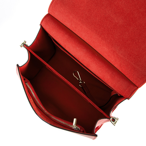 A top-down shot of an open red leather handbag with two main compartments and a zippered compartment.