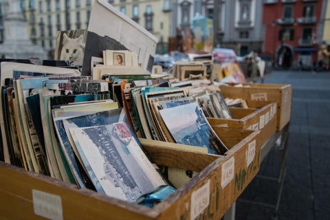 A selection of postcards in wooden display boxes on a streetcorner.